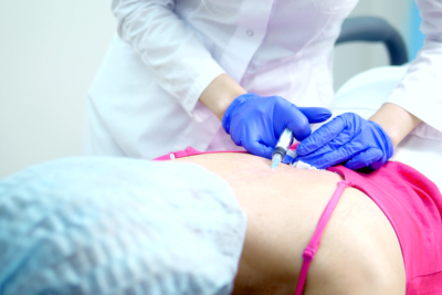 doctor injecting anesthesia to the patient in the back